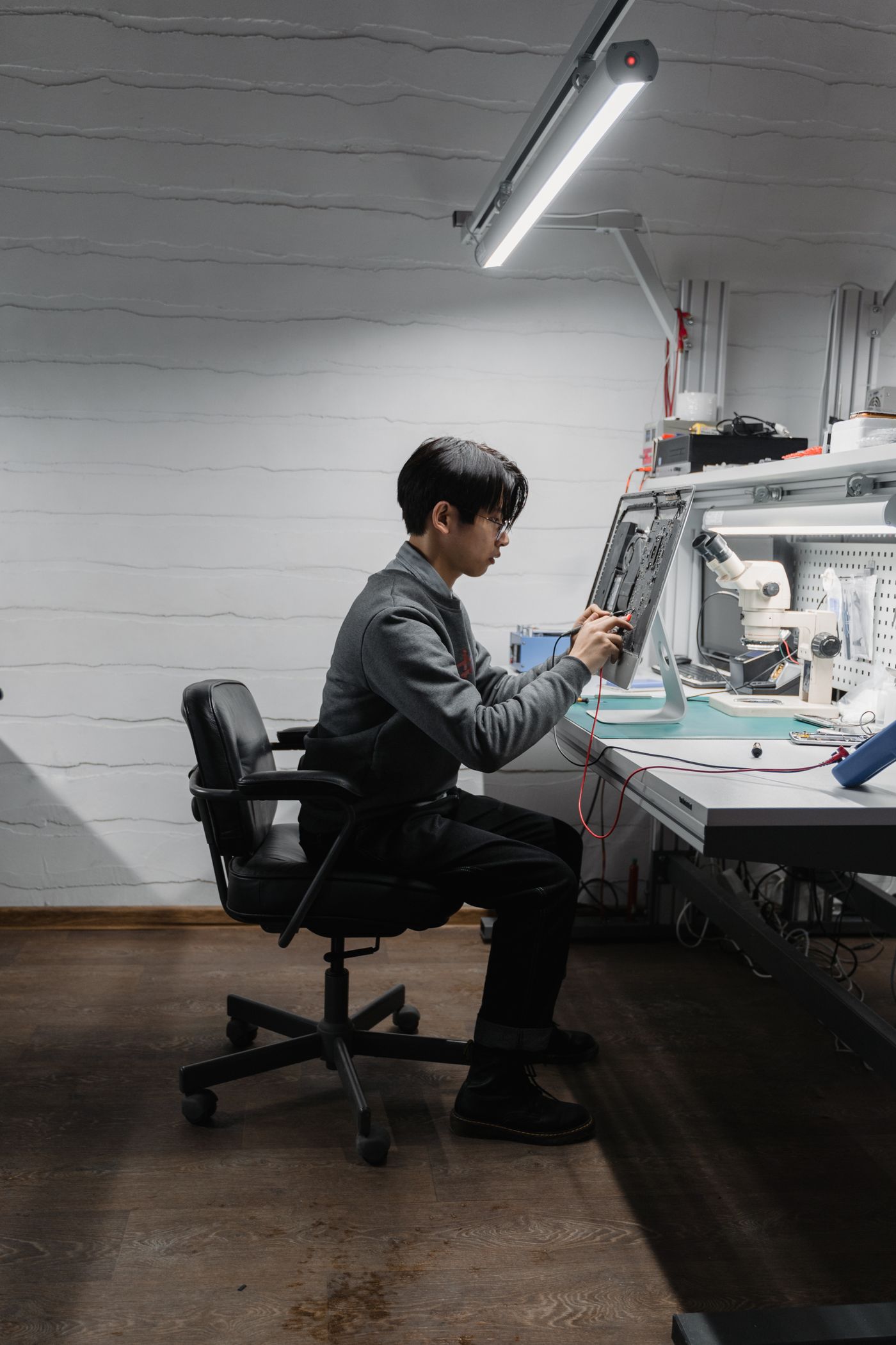 Electronics repair technician working at a repair bench